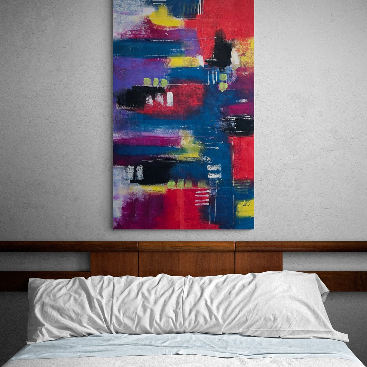 Original hand painted abstract wall art in a bedroom behind the wooden bed frame of a comfy bed