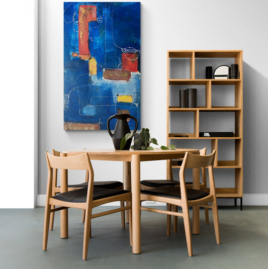 Bright dining room featuring wooden furniture with blue large abstract wall art.