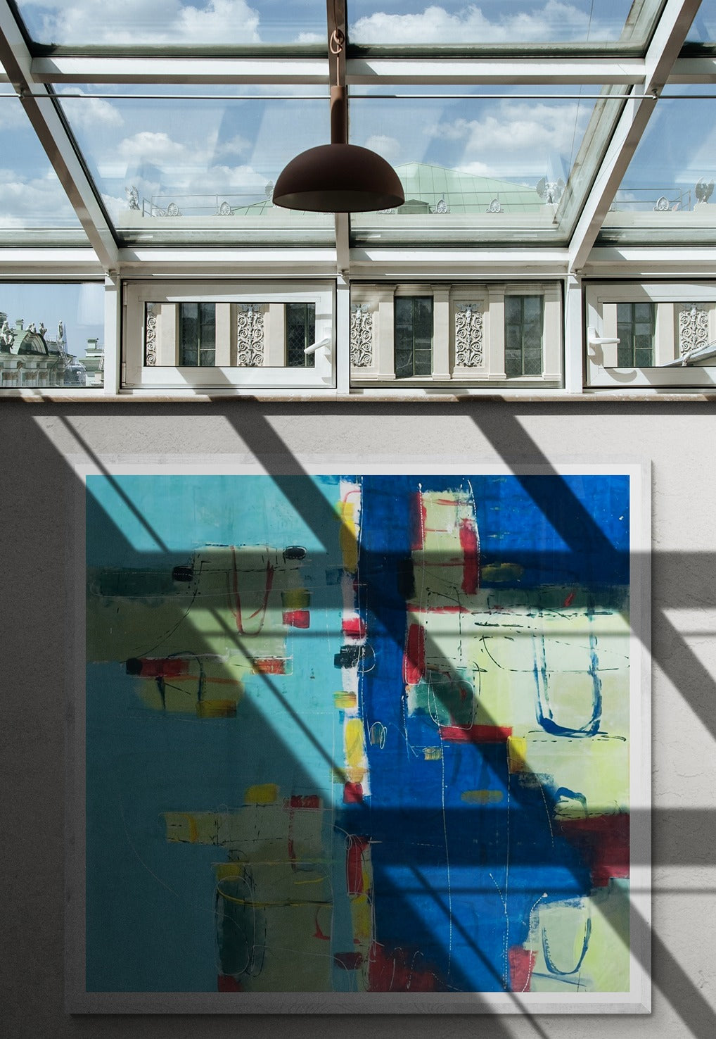 Large abstract hand-painted wall art with a window casting a shadow on an apartment wall.