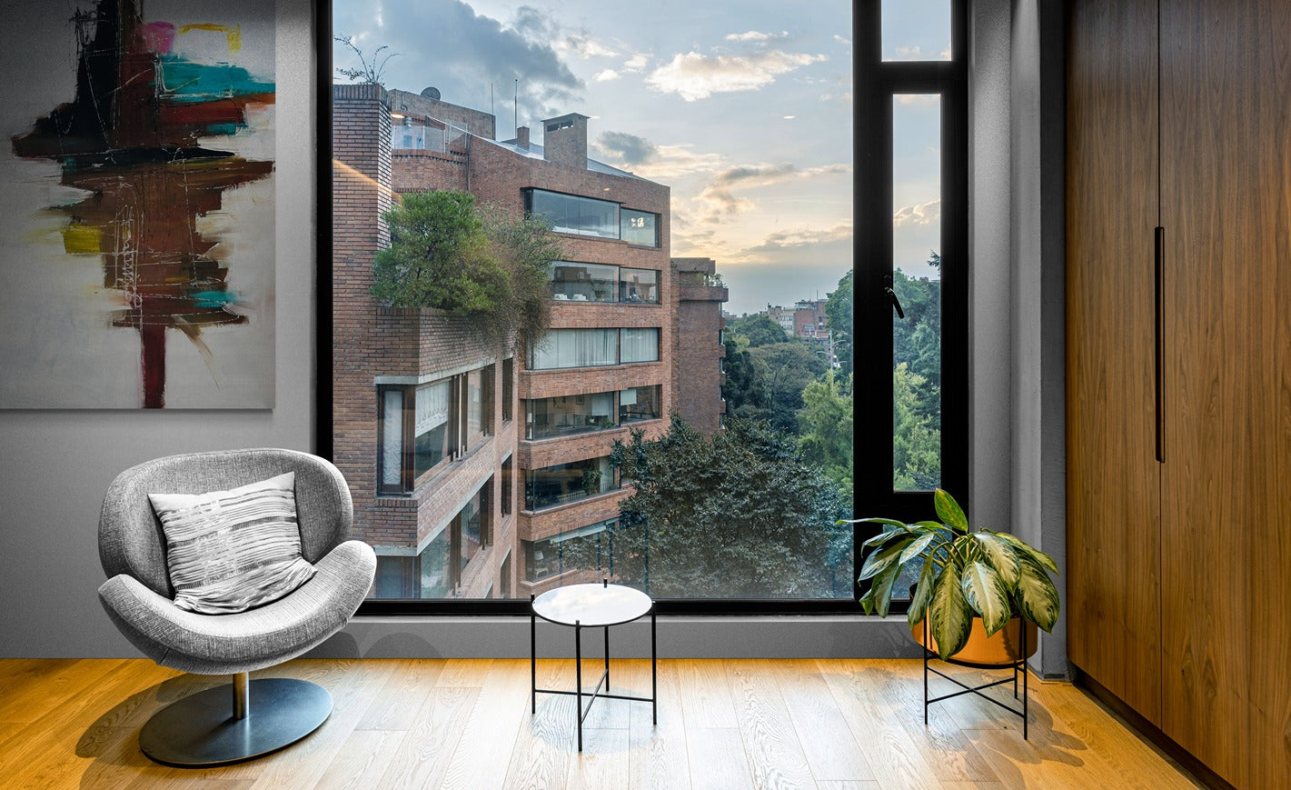 Large original hand-painted abstract canvas wall art in a stylish apartment living room with a large window, adding vibrant colors and artistic expression to the space.