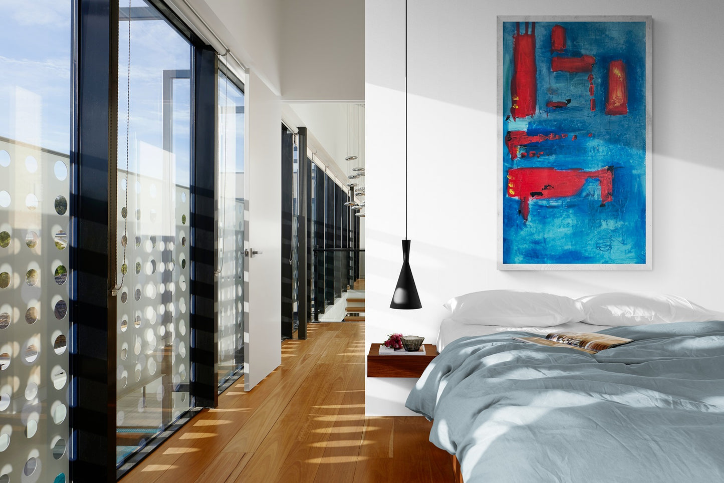 A large, hand-painted abstract wall art piece in a stylish apartment bedroom with large windows.