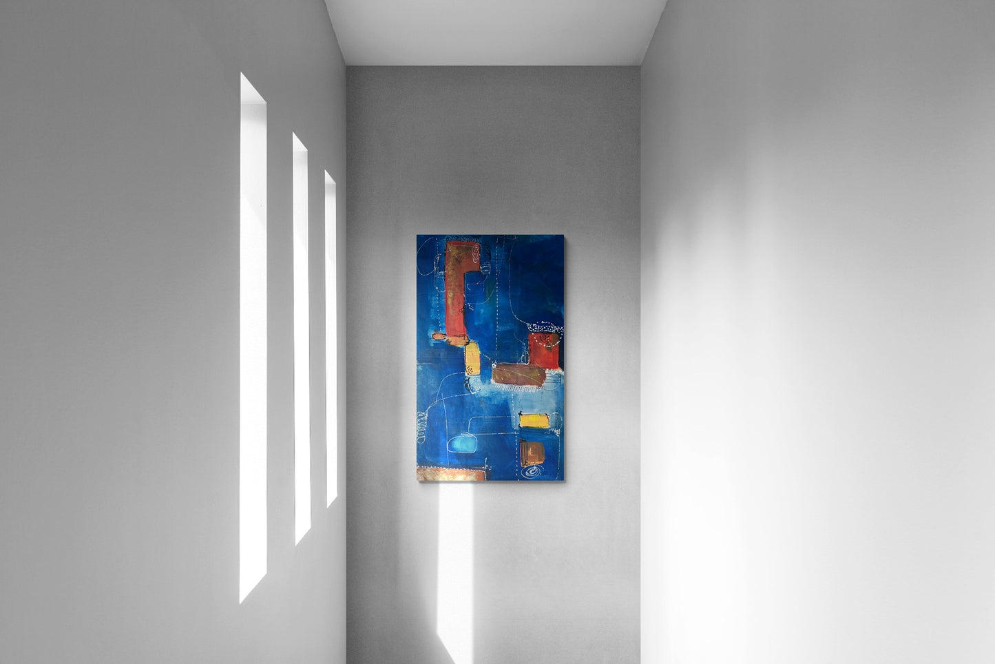 Natural light illuminating hallway wall with blue abstract canvas wall art.